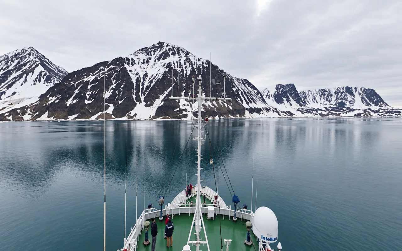 View from the research ship towards the mountains and still water of the Arctic